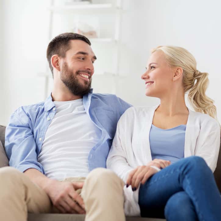 Illustration: A couple sitting on a sofa, gazing into each other's eyes and smiling.