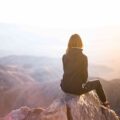 woman sitting on mountain top