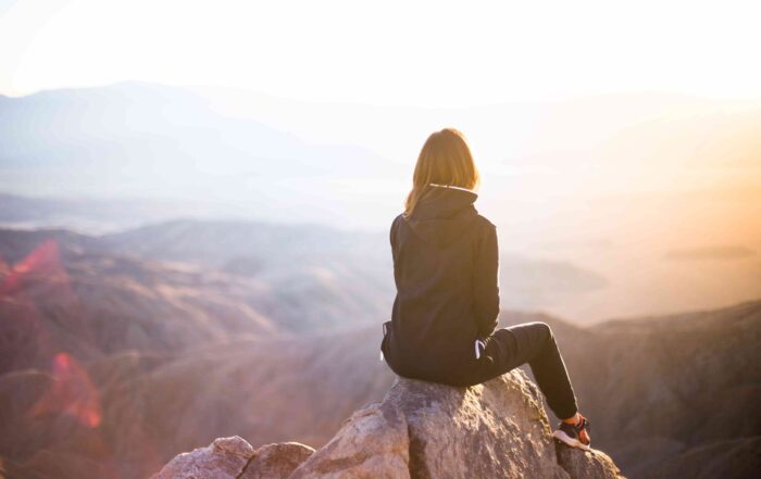 woman sitting on mountain top